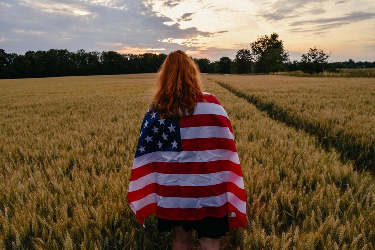 Foto vista traseira de mulher com bandeira americana no campo