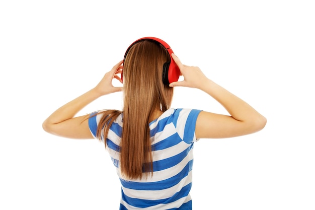 Foto vista traseira de mulher com fones de ouvido em frente a um fundo branco