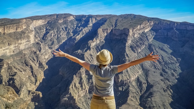 Foto vista traseira de mulher com os braços estendidos de pé na montanha