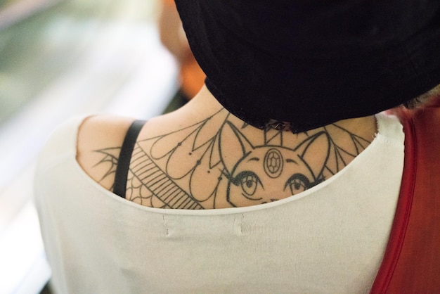 Vista traseira de mulher com tatuagem nas costas