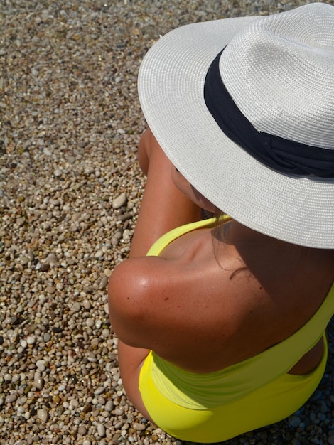 Foto vista traseira de mulher de biquíni usando chapéu na praia