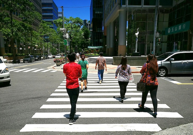 Vista traseira de pessoas caminhando na estrada na cidade