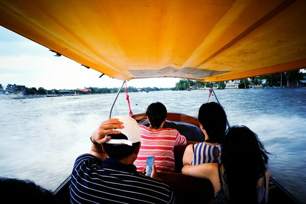 Vista traseira de pessoas em barco de velocidade no lago