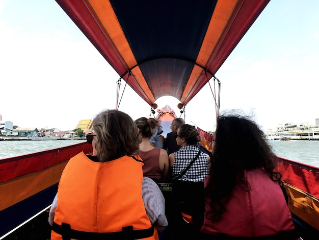 Vista traseira de pessoas em barco no mar