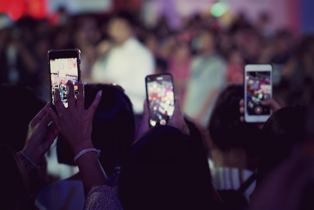 Foto vista traseira de pessoas fotografando à noite