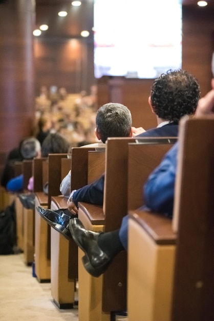 Foto vista traseira de pessoas sentadas em um seminário