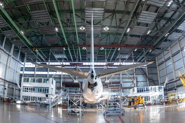 Vista traseira de um avião de passageiros branco no hangar de aviação Aeronaves em manutenção