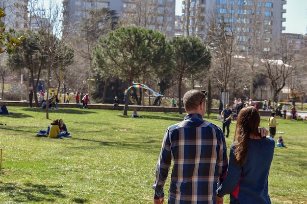 Foto vista traseira de um casal de mãos dadas no parque