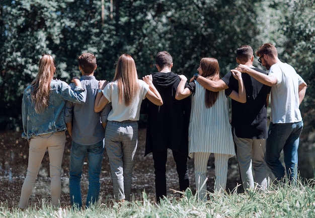 Vista traseira de um grupo de jovens caminhando no Parko conceito de formação de equipes