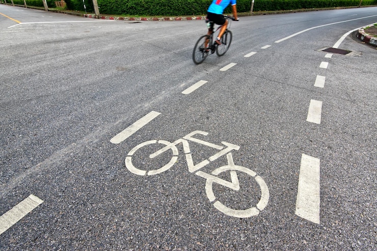 Foto vista traseira de um homem andando de bicicleta na rua