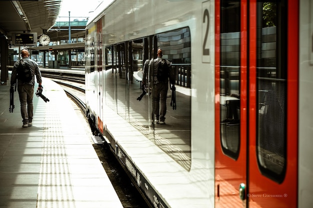 Foto vista traseira de um homem caminhando de trem na estação ferroviária