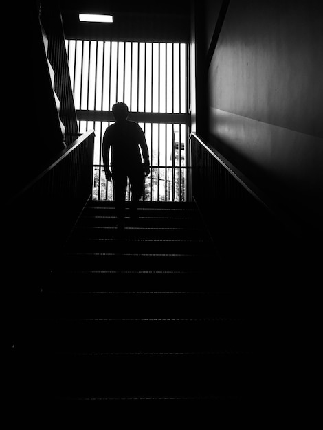 Foto vista traseira de um homem caminhando na escada rolante