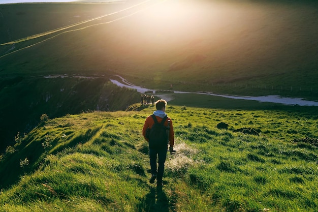 Foto vista traseira de um homem caminhando na montanha