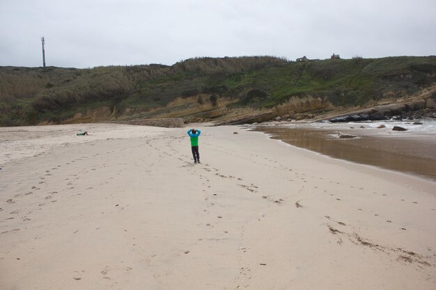 Foto vista traseira de um homem caminhando na praia