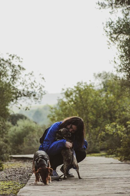 Foto vista traseira de um homem com um cão contra o céu