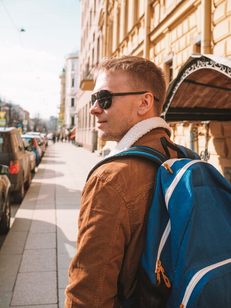 Vista traseira de um homem com uma mochila explorando a rua de São Petersburgo