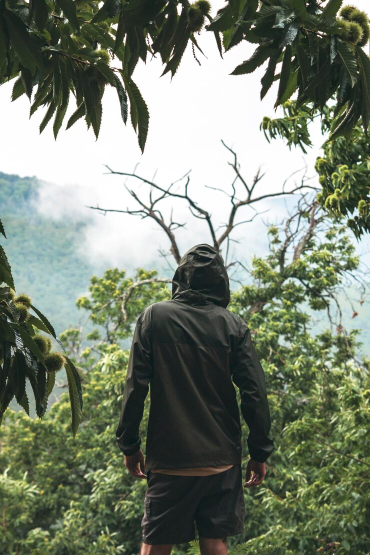 Foto vista traseira de um homem de pé junto a uma árvore