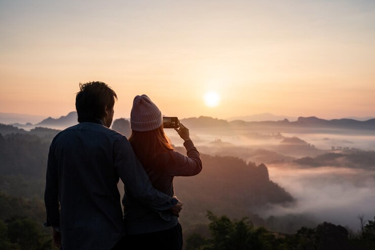 Foto vista traseira de um homem de pé na montanha contra o céu durante o pôr do sol