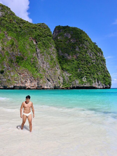 Foto vista traseira de um homem de pé na praia contra o céu