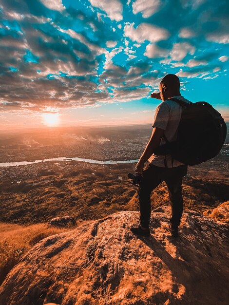 Foto vista traseira de um homem de pé na rua durante o pôr do sol