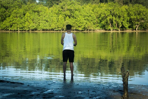 Foto vista traseira de um homem de pé no lago