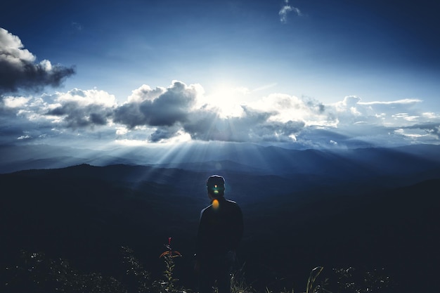 Foto vista traseira de um homem de pé pela montanha contra o céu