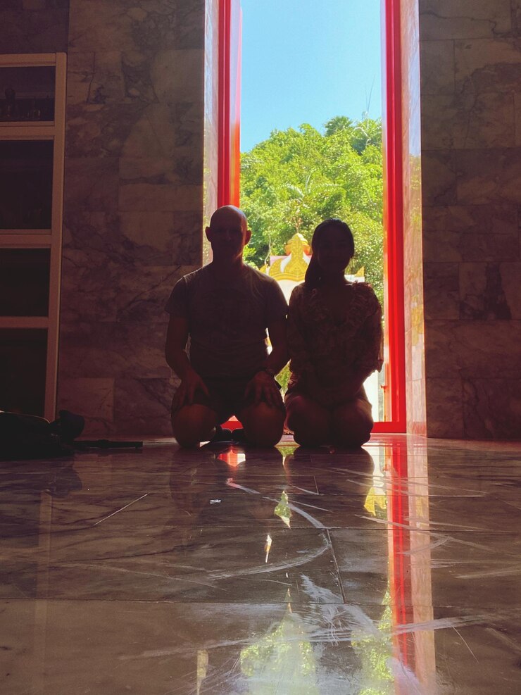 Foto vista traseira de um homem e uma mulher sentados no chão de um edifício