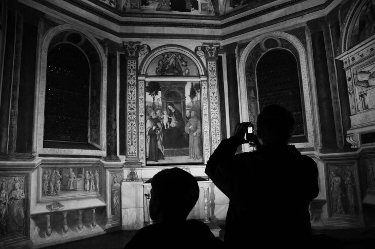 Foto vista traseira de um homem em silhueta fotografando na igreja