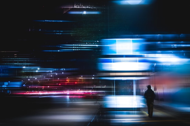 Vista traseira de um homem em uma cidade iluminada à noite