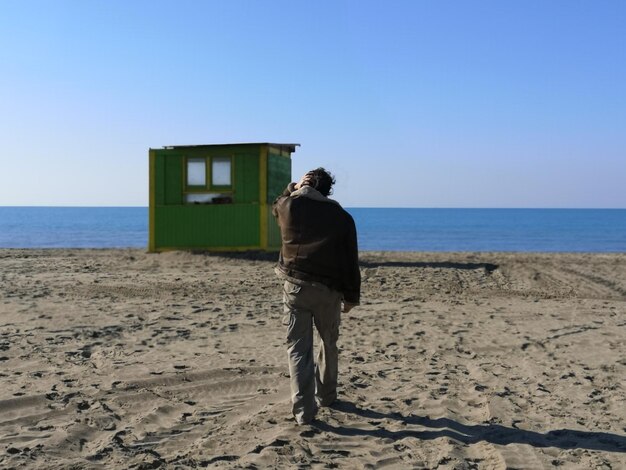 Foto vista traseira de um homem na praia contra um céu claro