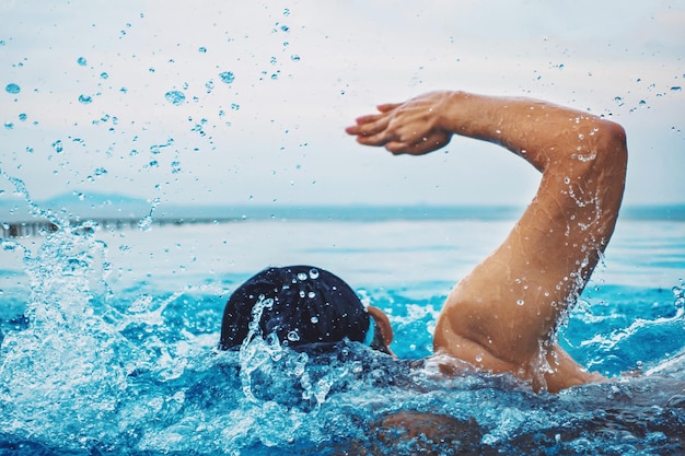 Vista traseira de um homem nadando na piscina