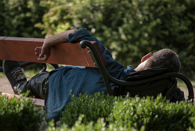 Foto vista traseira de um homem relaxando em um banco de parque