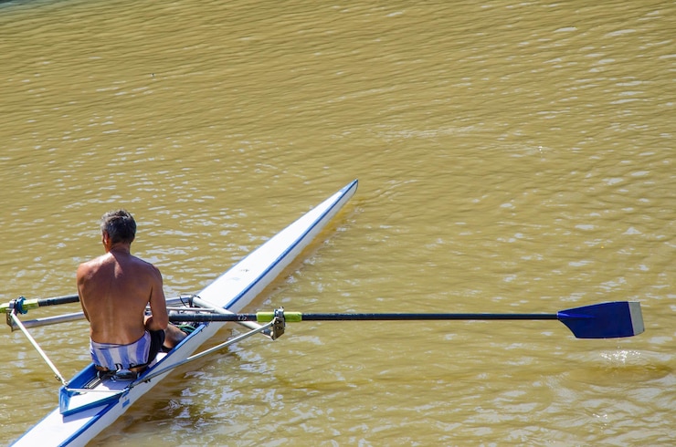 Foto vista traseira de um homem sentado em um barco no lago