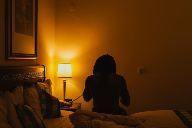 Vista traseira de um homem sentado na cama