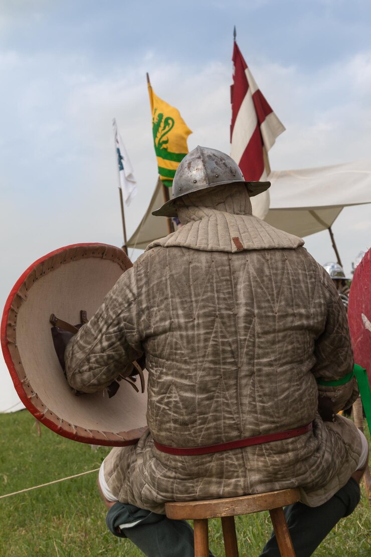 Foto vista traseira de um homem vestindo roupas tradicionais sentado em um banquinho contra o céu