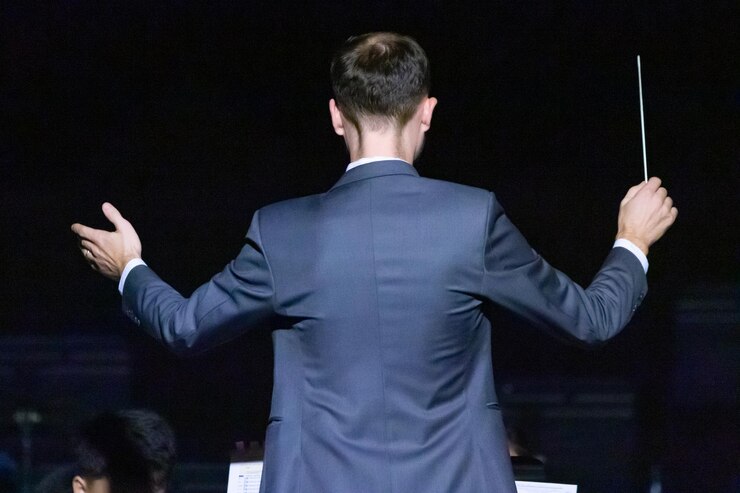 Foto vista traseira de um maestro de música bem vestido fazendo gestos
