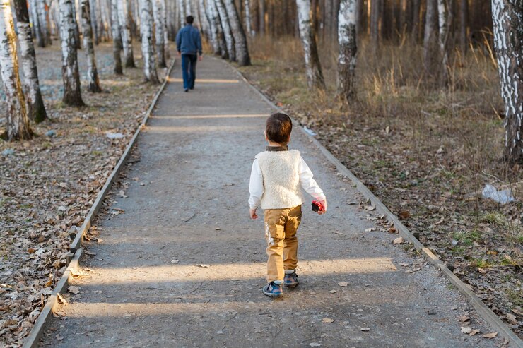 Foto vista traseira de um menino caminhando por uma trilha