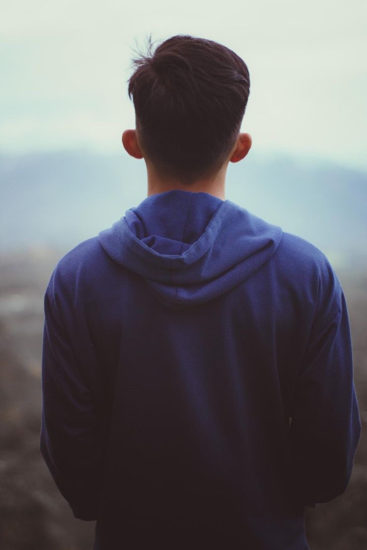 Foto vista traseira de um menino de pé contra o céu