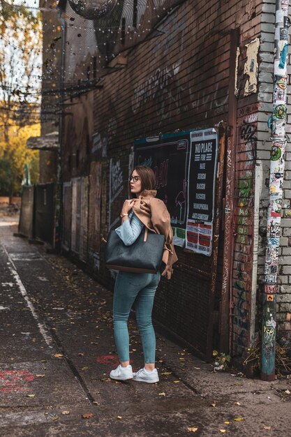 Foto vista traseira de uma jovem caminhando por uma calçada na cidade