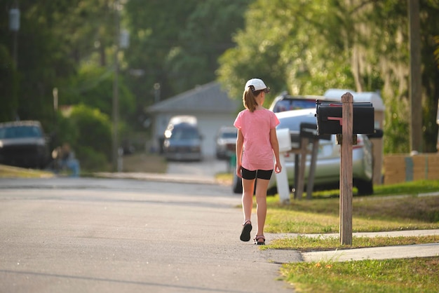 Vista traseira de uma jovem confiante caminhando ao longo do beco ensolarado Estilo de vida ativo nas férias de verão