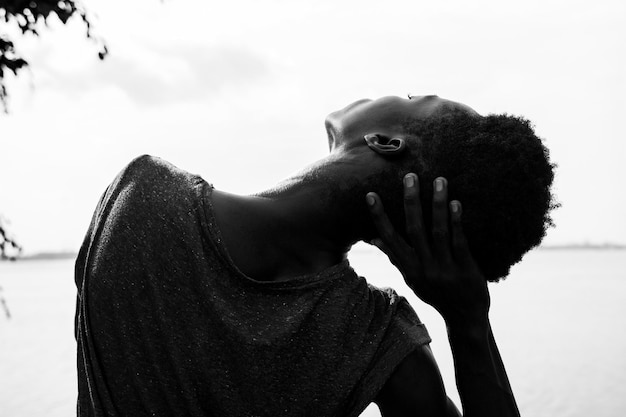 Vista traseira de uma jovem estendendo o pescoço contra o céu