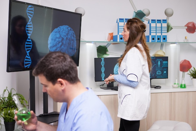 Foto vista traseira de uma médica examinando um paciente na clínica