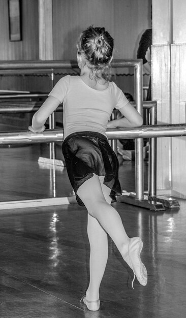 Foto vista traseira de uma menina dançando balé no estúdio