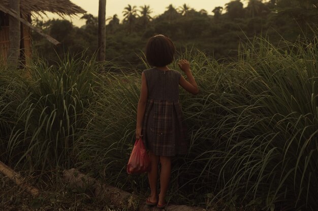 Foto vista traseira de uma menina de pé no campo