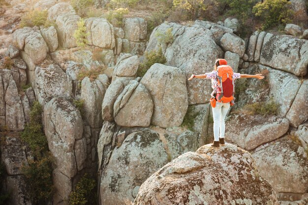 Vista traseira de uma mulher aventureira perto do desfiladeiro na rocha