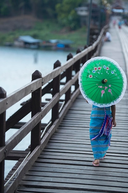 Foto vista traseira de uma mulher caminhando com um guarda-chuva