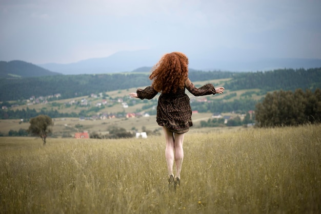Vista traseira de uma mulher caminhando em um campo gramado