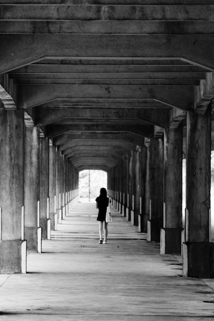 Vista traseira de uma mulher caminhando em um túnel