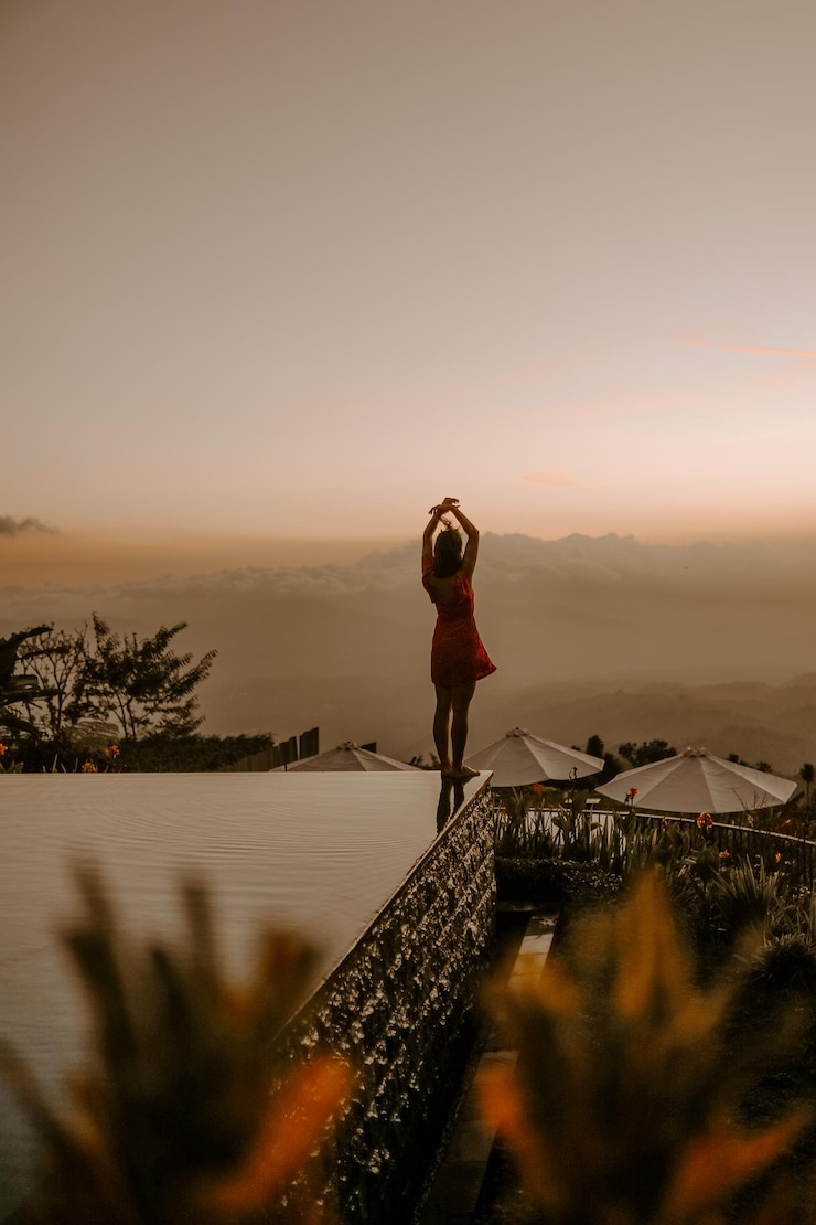 Foto vista traseira de uma mulher caminhando na praia contra o céu durante o pôr do sol