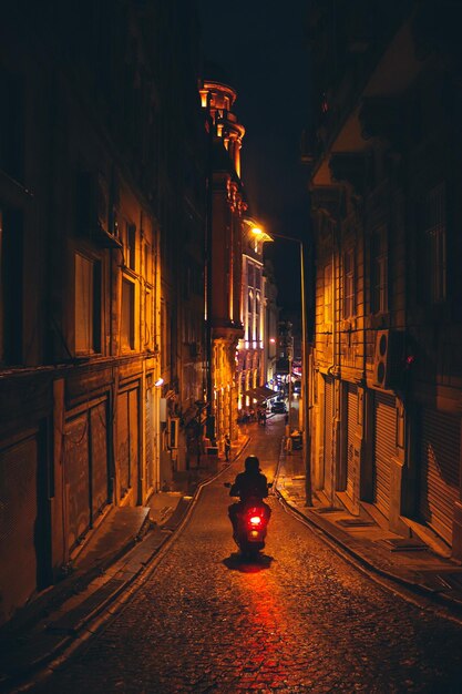 Foto vista traseira de uma mulher caminhando na rua à noite